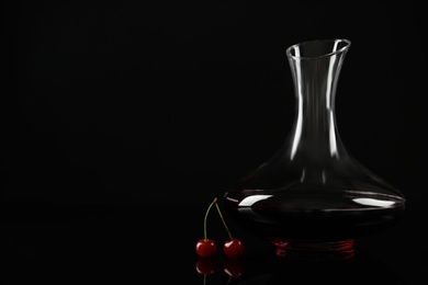 Photo of Delicious cherry wine and ripe juicy berries on black background. Space for text