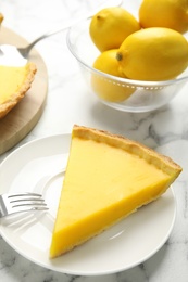 Photo of Slice of delicious homemade lemon pie on white marble table