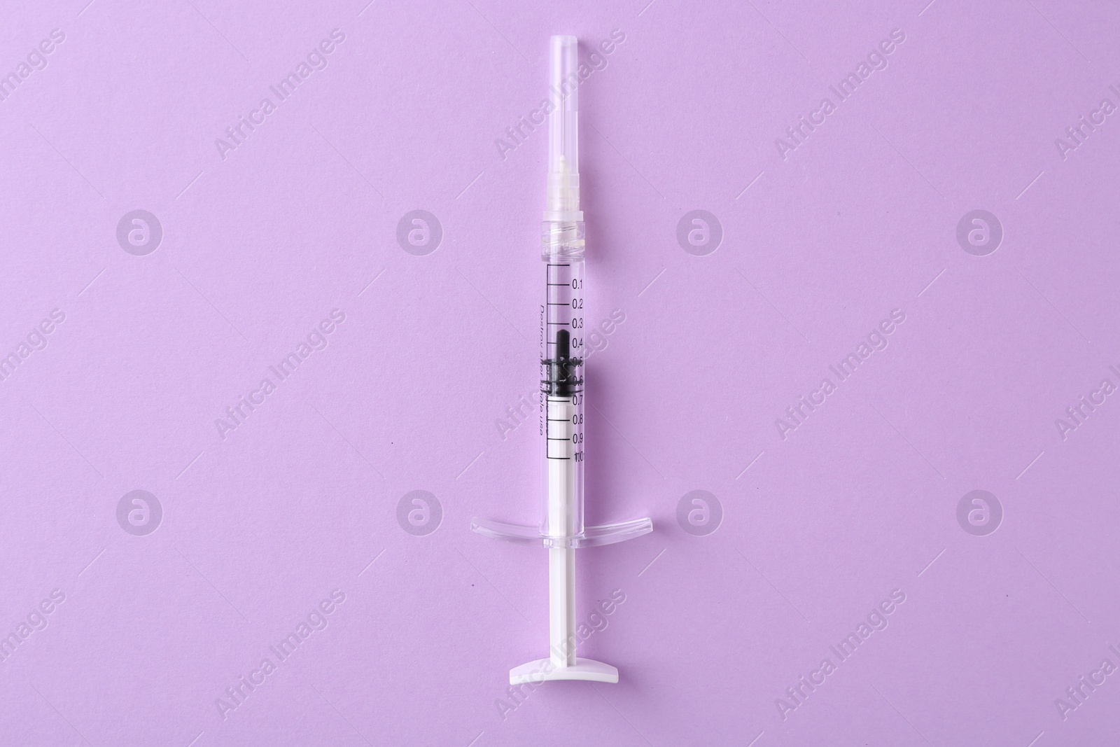 Photo of Cosmetology. One medical syringe on violet background, top view