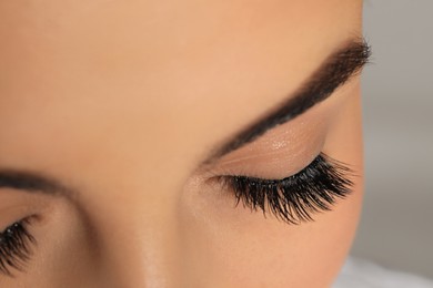 Photo of Beautiful young woman with long eyelashes on light background, closeup