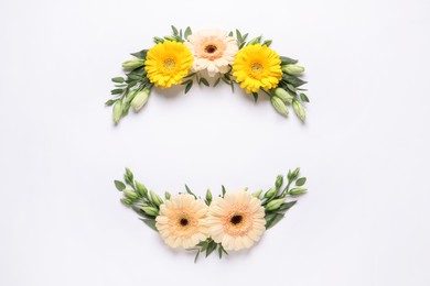 Photo of Wreathes made of beautiful flowers and green leaves on white background, flat lay. Space for text