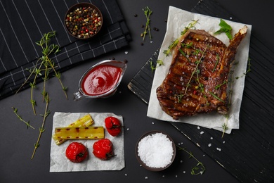 Flat lay composition with grilled meat on black background