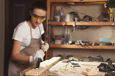 Photo of Professional carpenter working with wooden plank in workshop