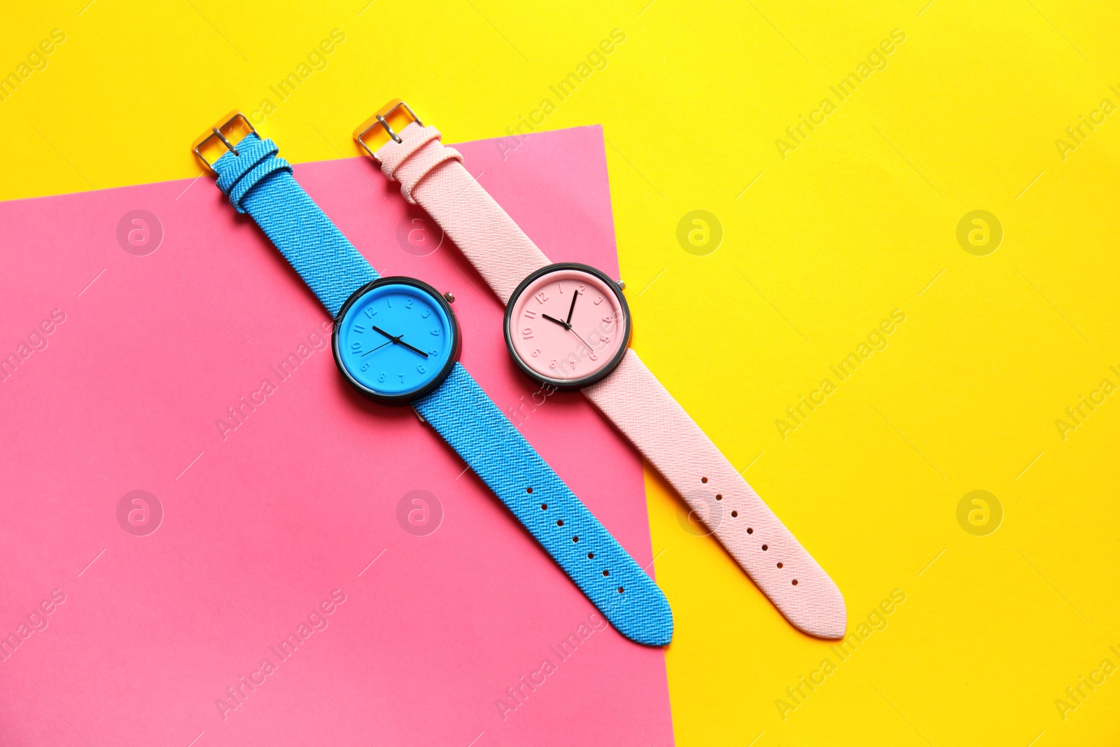 Photo of Composition with stylish wrist watches on color background, flat lay. Fashion accessory