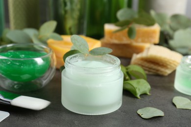 Photo of Homemade cosmetic products, fresh ingredients and brush on black table, closeup