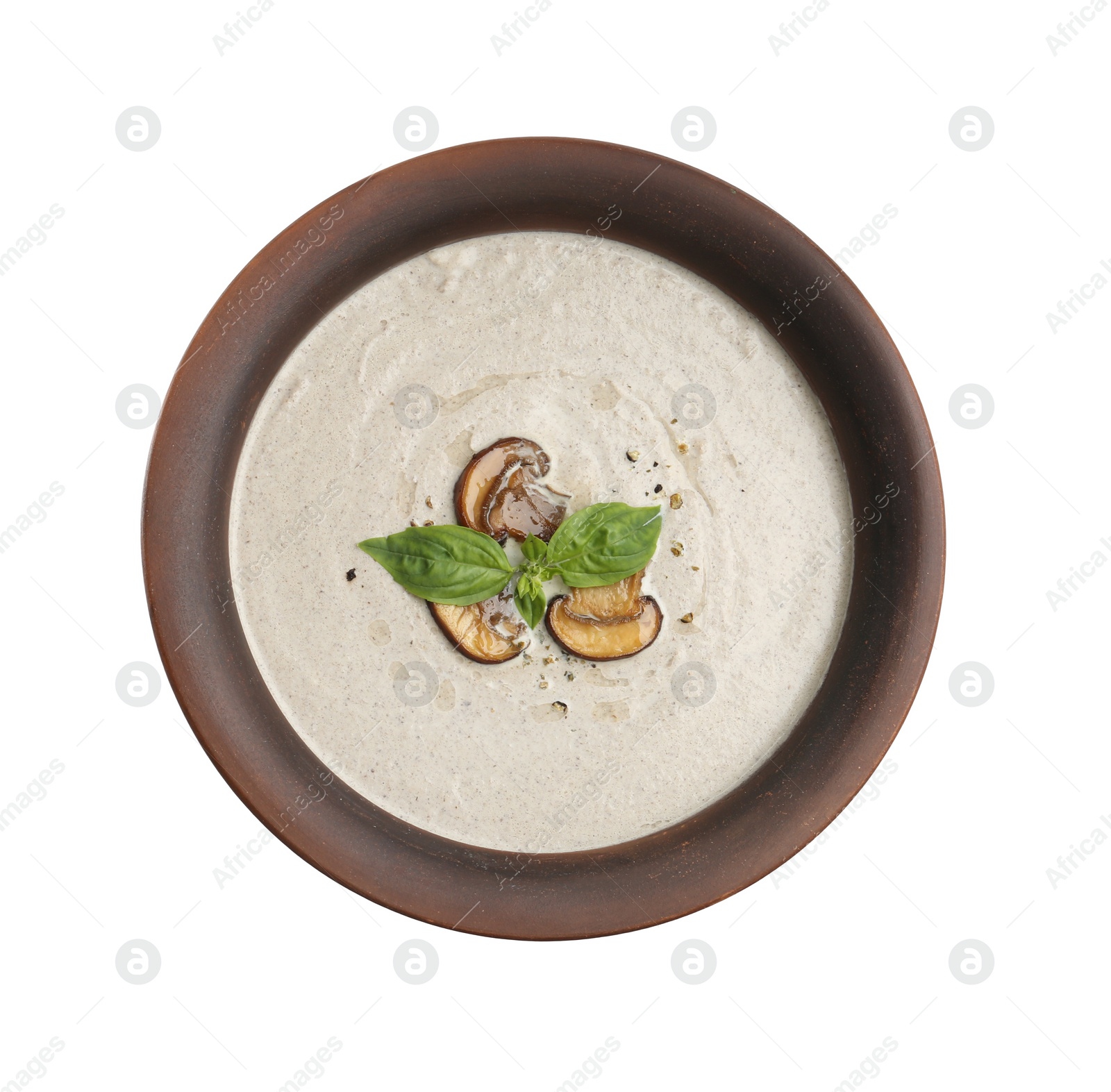 Photo of Fresh homemade mushroom soup in ceramic pot isolated on white, top view