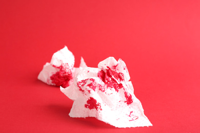Photo of Sheets of toilet paper with blood on red background. Hemorrhoid problems