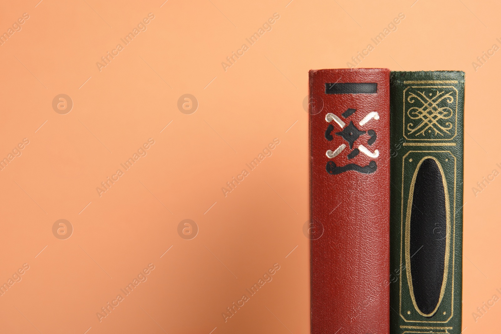 Photo of Old books on peach background, space for text