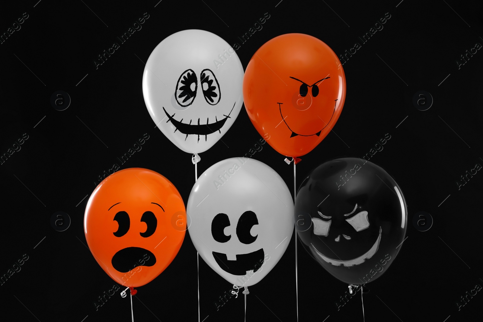 Photo of Spooky balloons for Halloween party on black background