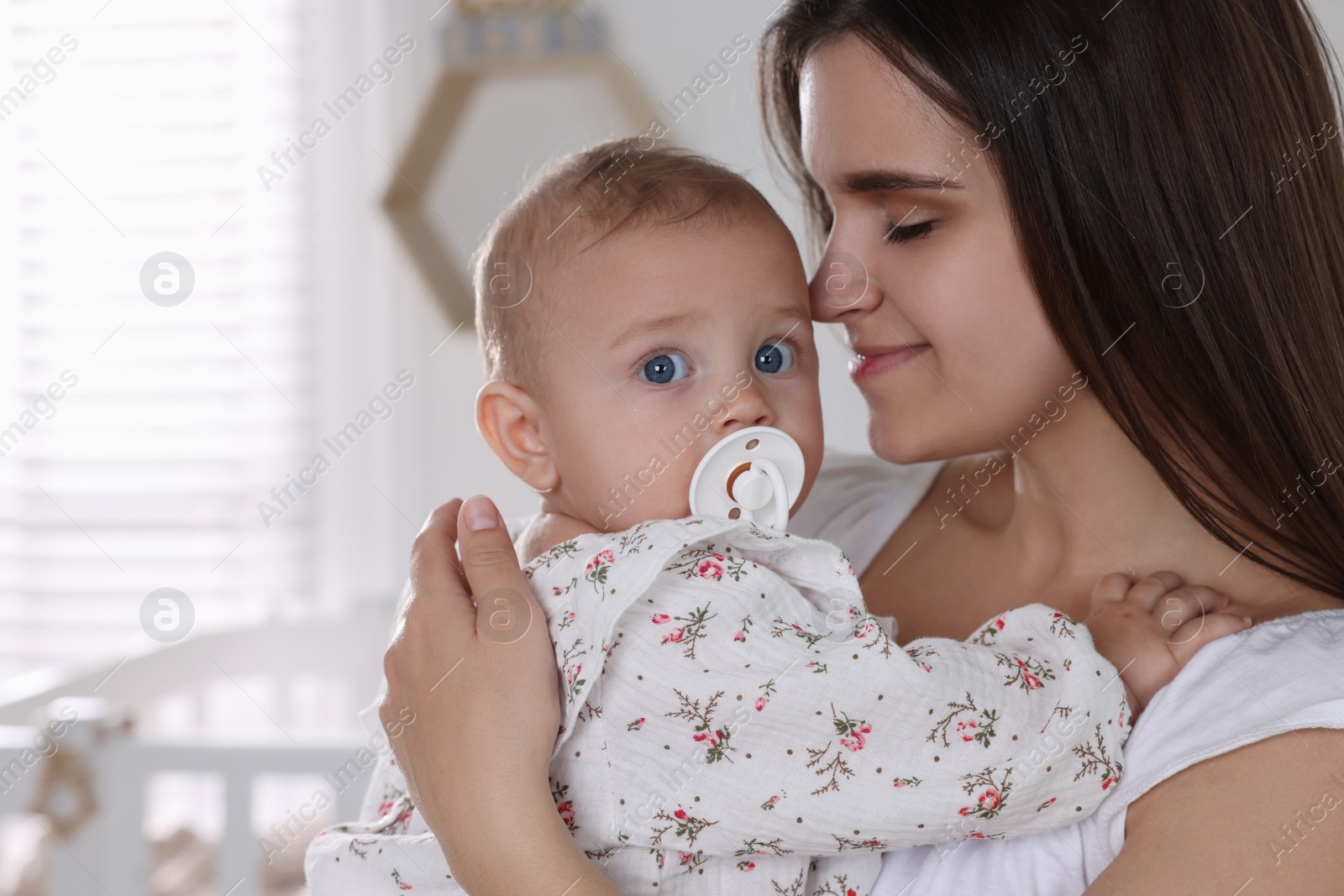 Photo of Happy young mother with her baby daughter at home