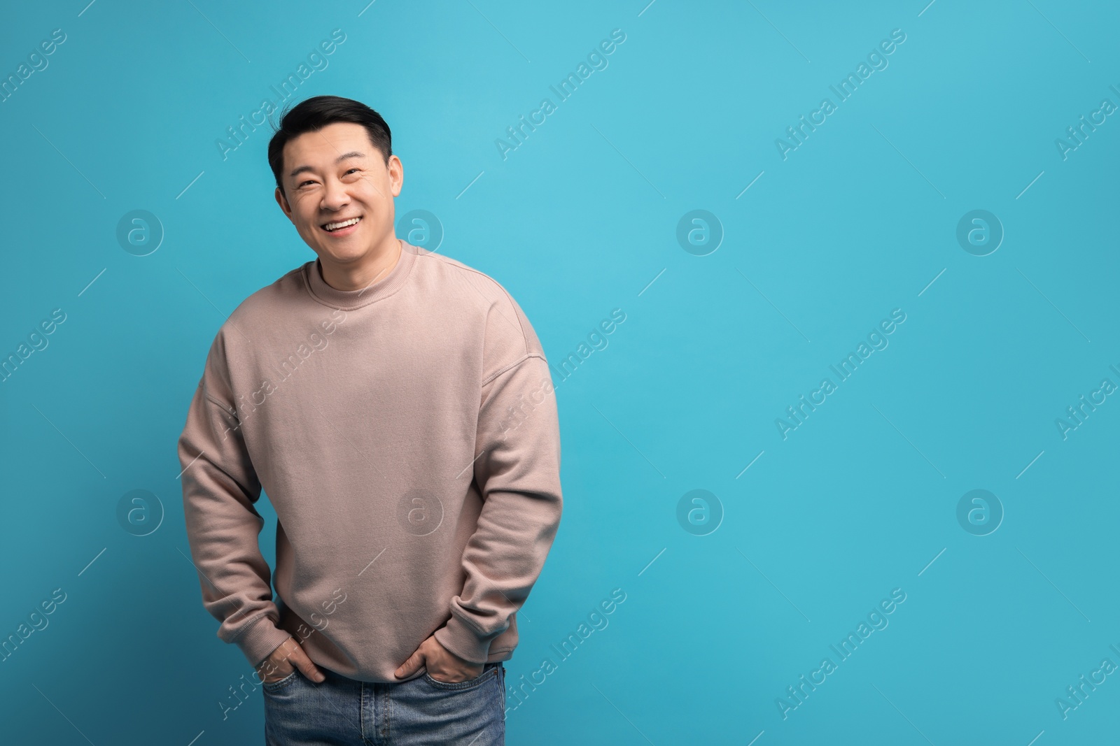 Photo of Portrait of happy man on light blue background. Space for text