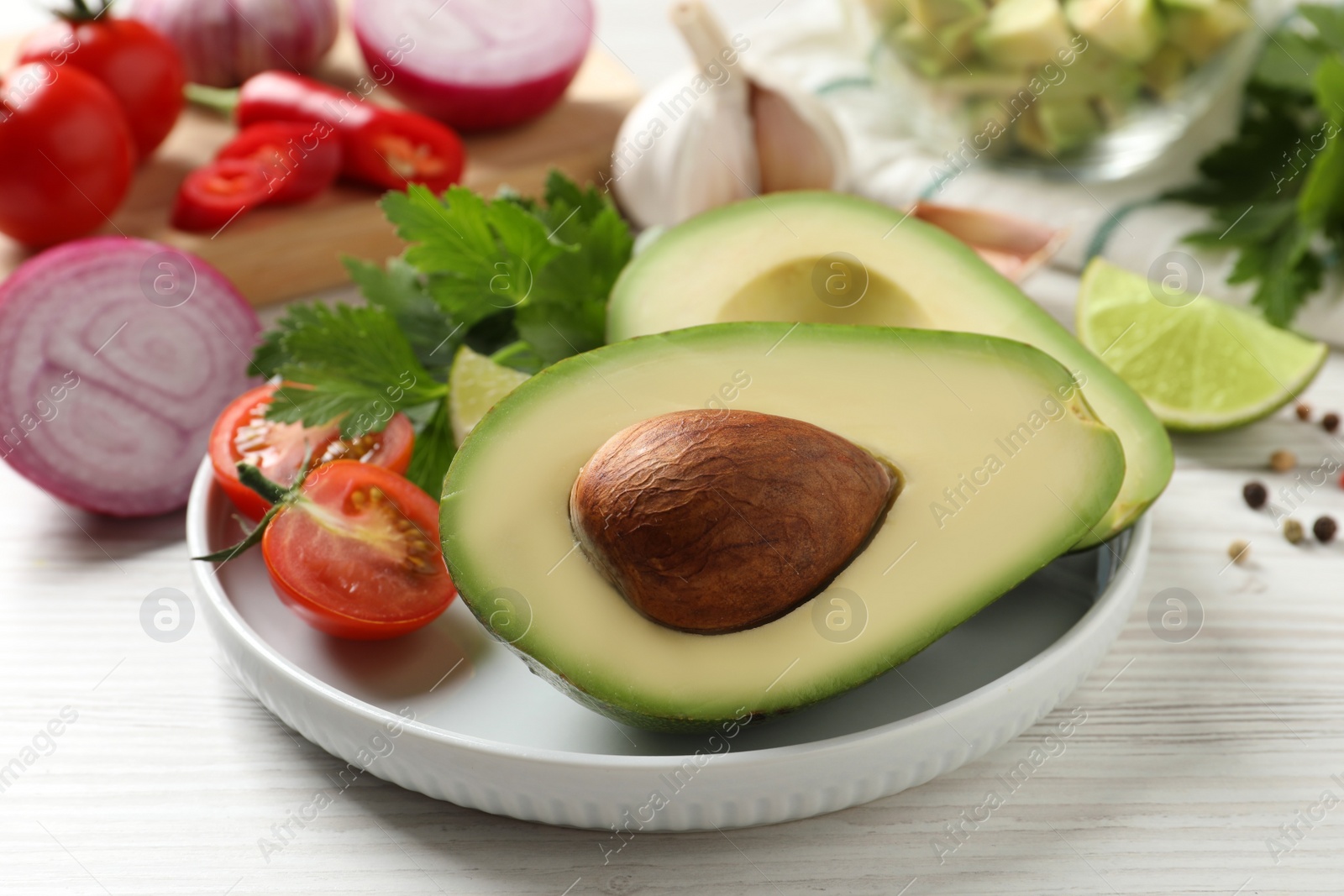 Photo of Fresh ingredients for guacamole on white wooden table