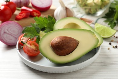 Fresh ingredients for guacamole on white wooden table