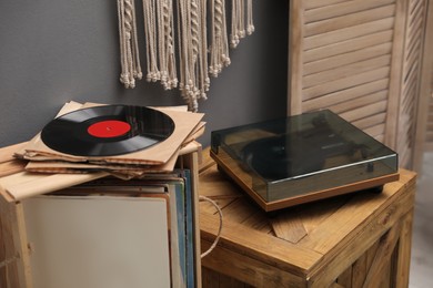 Stylish turntable on wooden crate in room