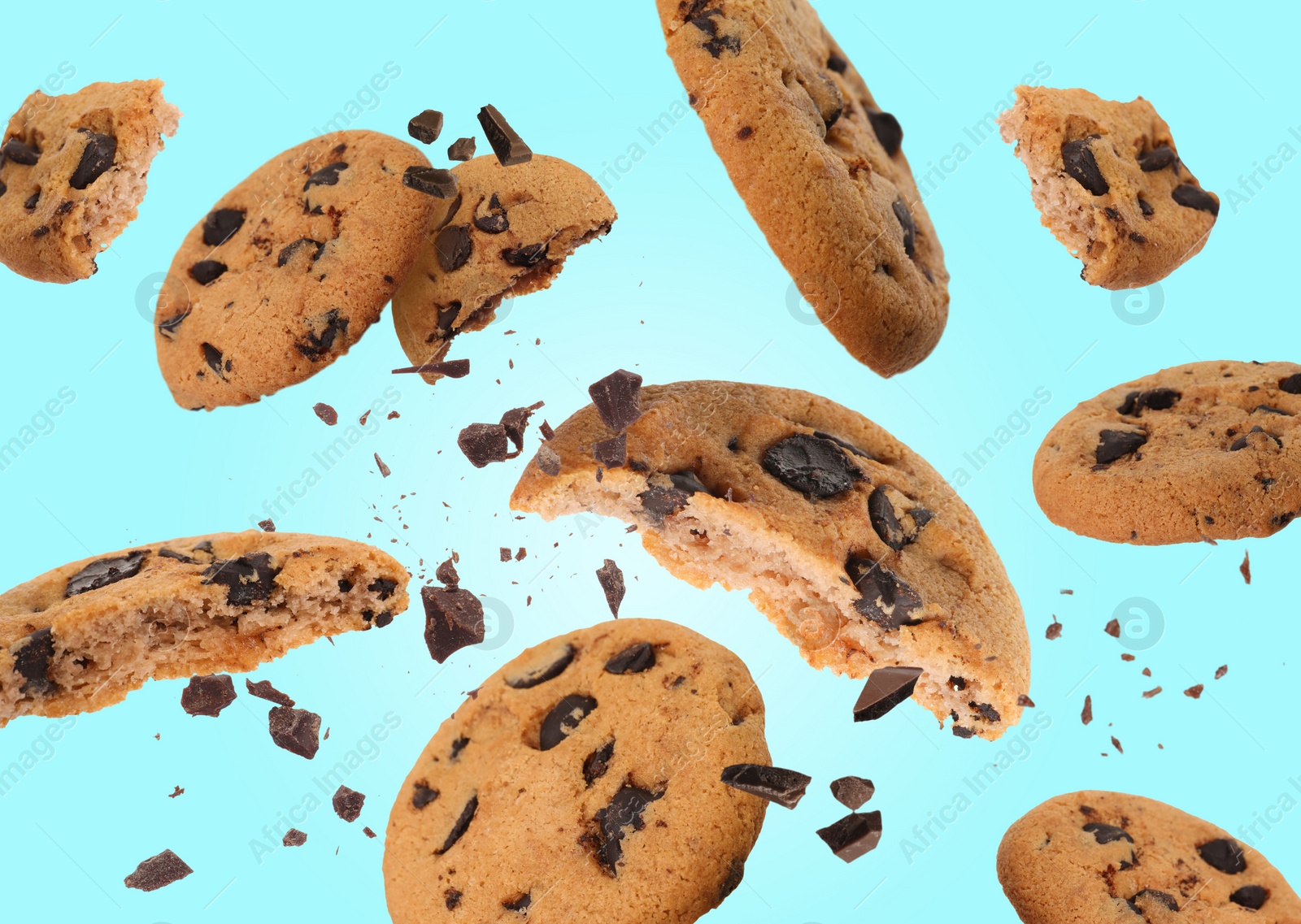 Image of Tasty chocolate chip cookies falling on light blue background