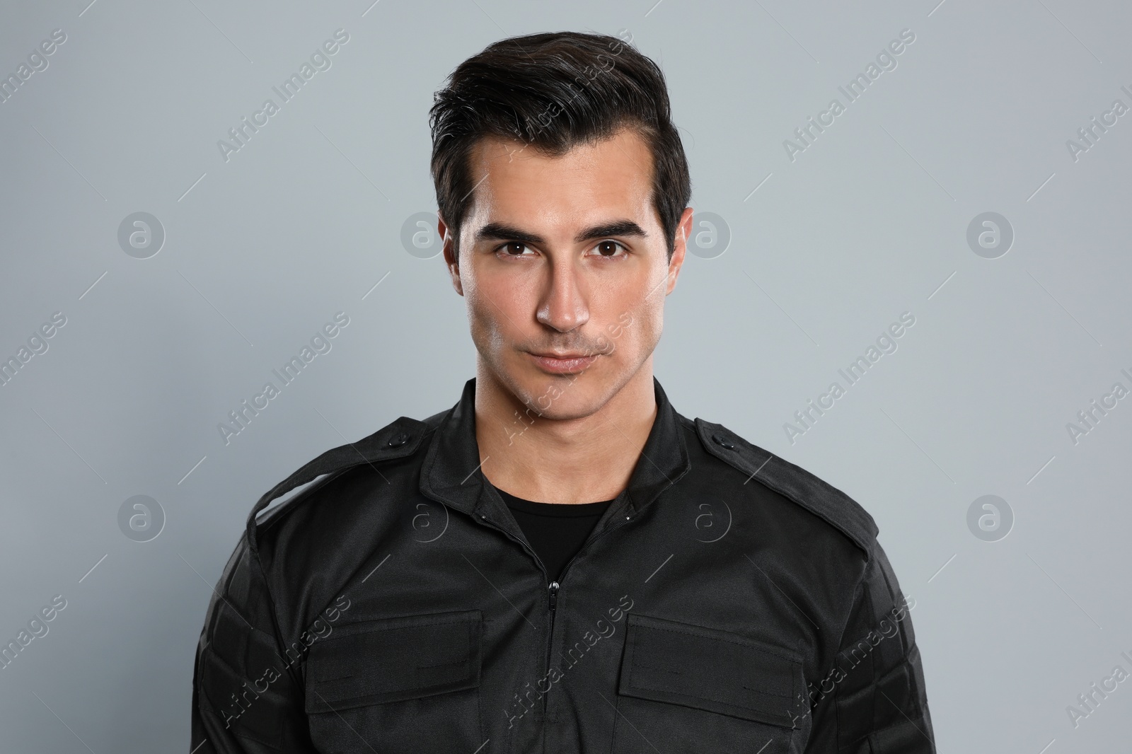 Photo of Male security guard in uniform on grey background