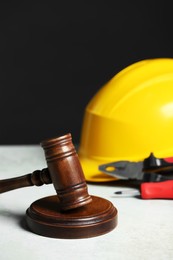 Construction and land law concepts. Gavel, hard hat and different tools on white table