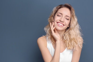 Young woman with beautiful smile on color background. Teeth whitening