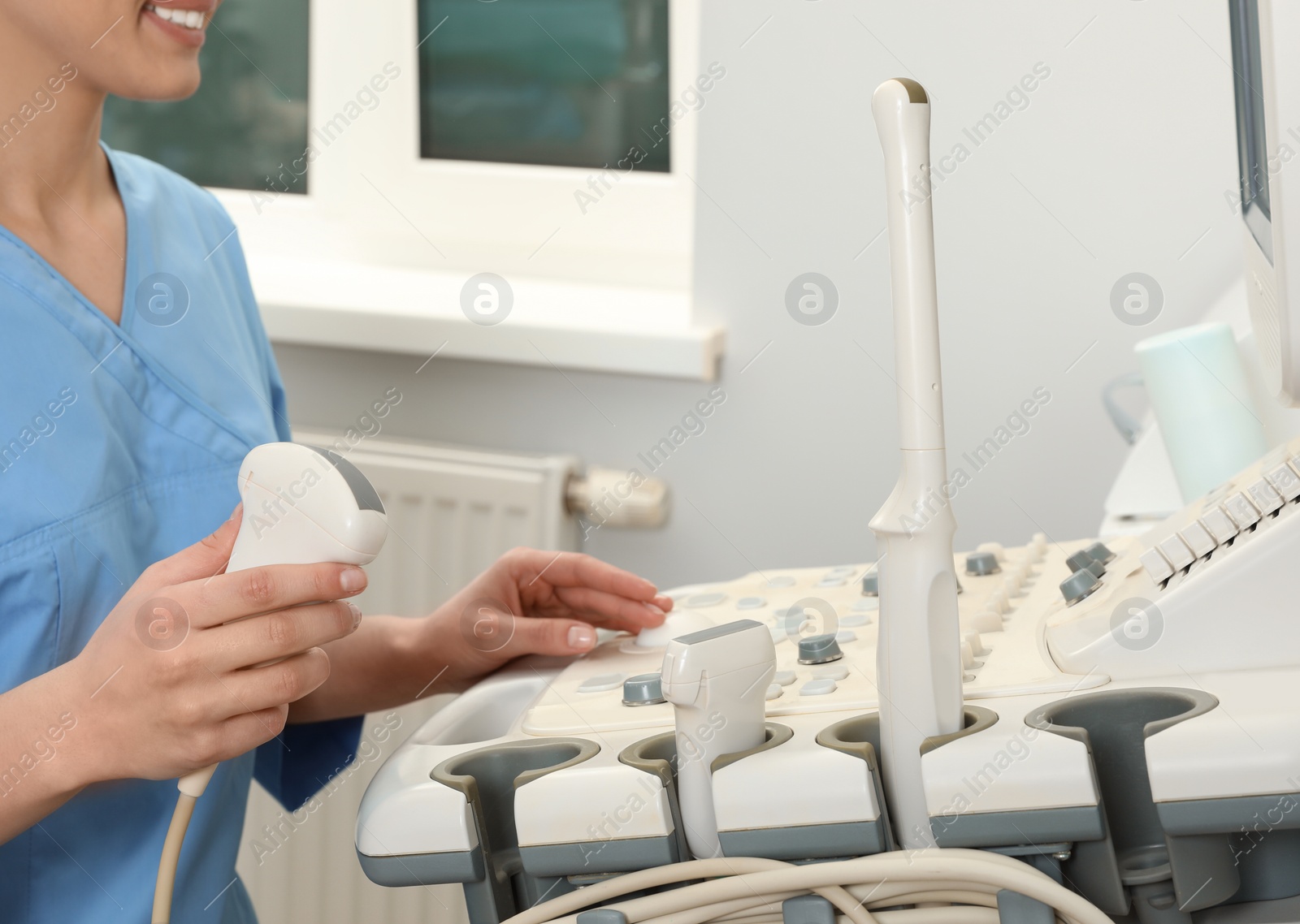 Photo of Sonographer operating modern ultrasound machine in clinic, closeup