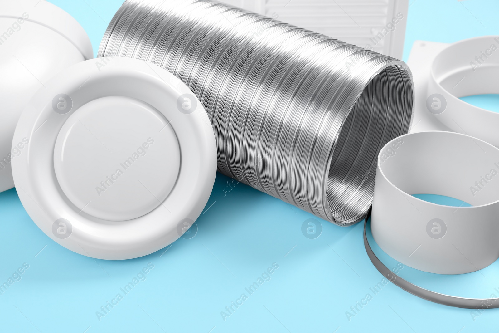 Photo of Parts of home ventilation system on light blue background, closeup