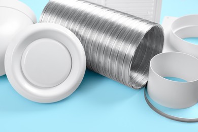 Photo of Parts of home ventilation system on light blue background, closeup