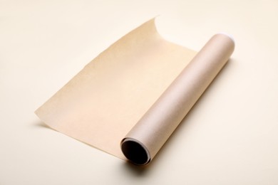 Photo of Roll of baking paper on beige background