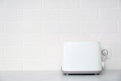 Photo of Modern toaster on countertop in kitchen. Space for text