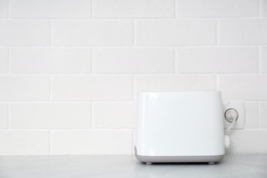 Modern toaster on countertop in kitchen. Space for text