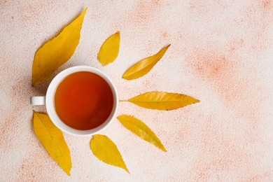 Autumn leaves and cup of tasty tea on color background, flat lay. Space for text