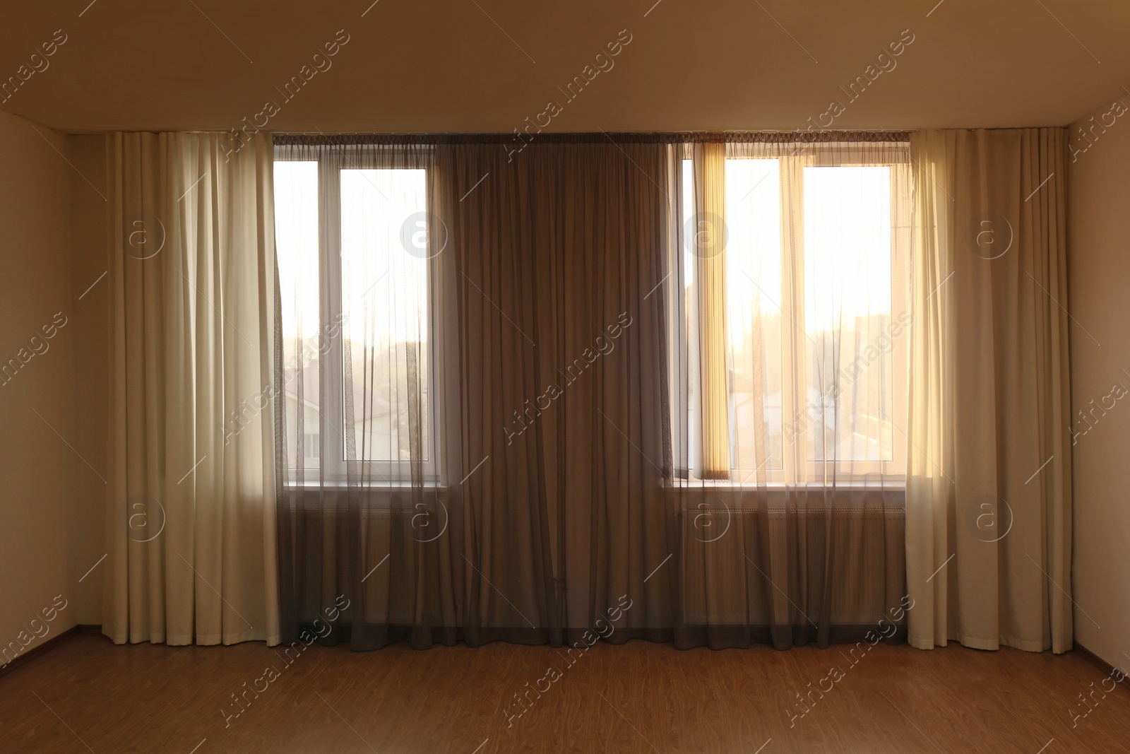 Photo of Windows with beautiful curtains in empty room