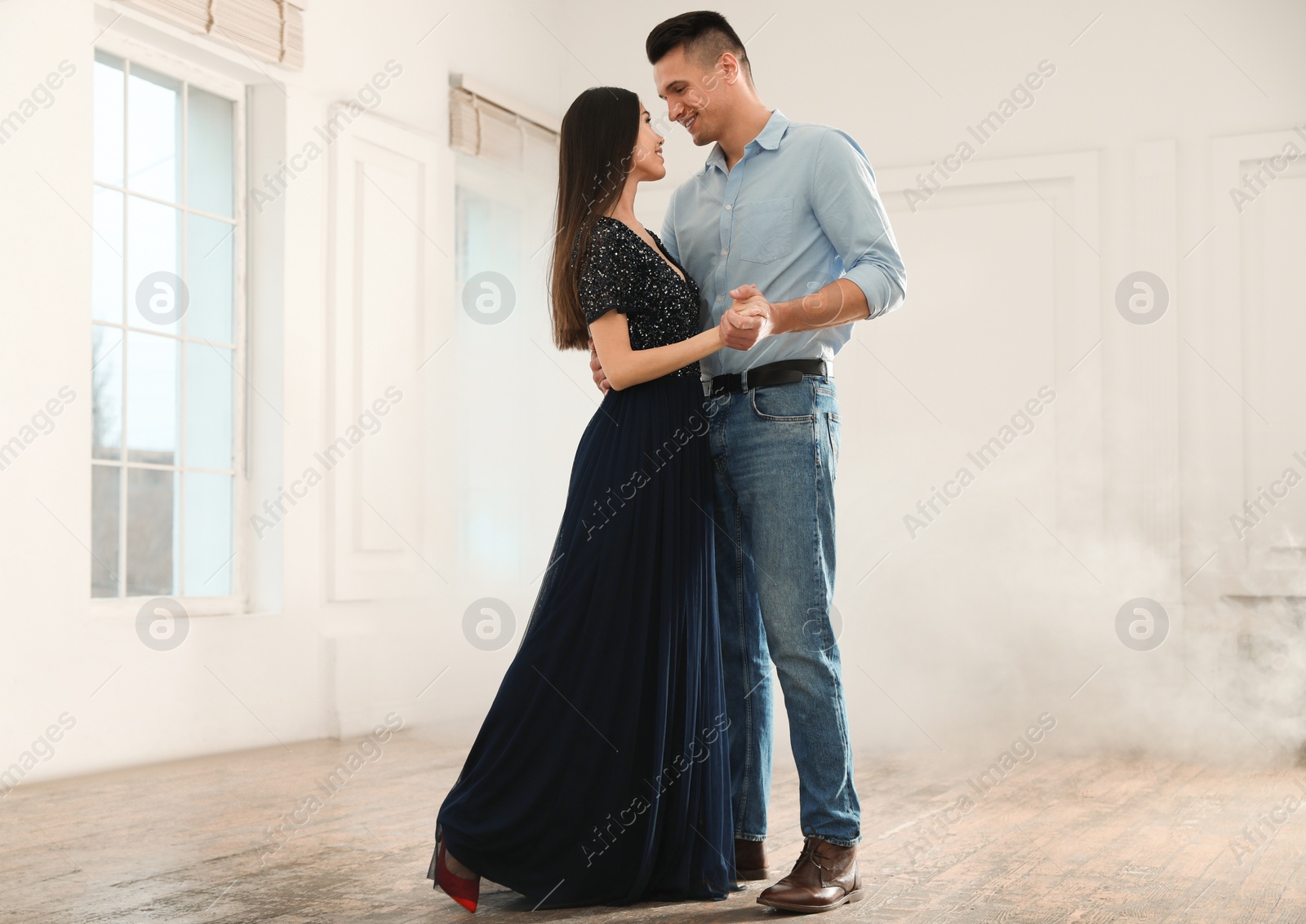 Photo of Lovely young couple dancing together in ballroom