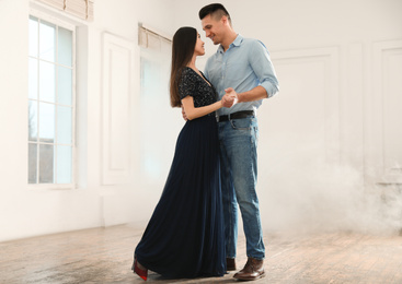 Photo of Lovely young couple dancing together in ballroom