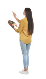 Photo of Young woman drawing with brush on white background, back view