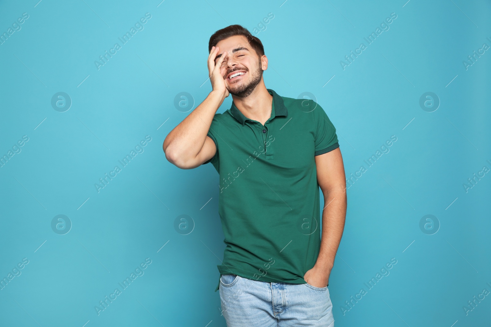 Photo of Portrait of young man laughing on color background