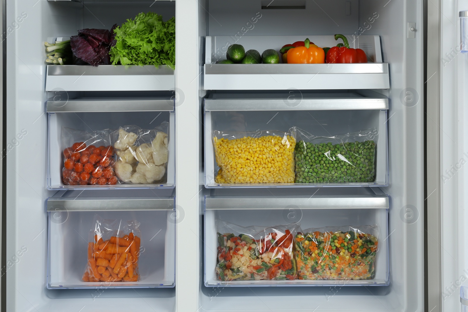 Photo of Open refrigerator with different vegetables, closeup view