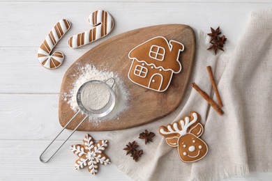 Delicious Christmas cookies and ingredients on white wooden table, flat lay