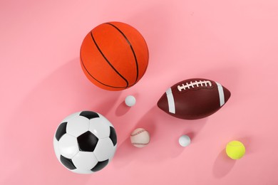 Photo of Many different sports balls on pink background, flat lay
