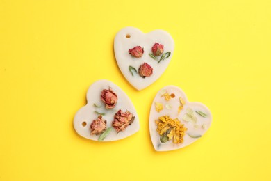 Photo of Beautiful scented sachets with flowers on yellow background