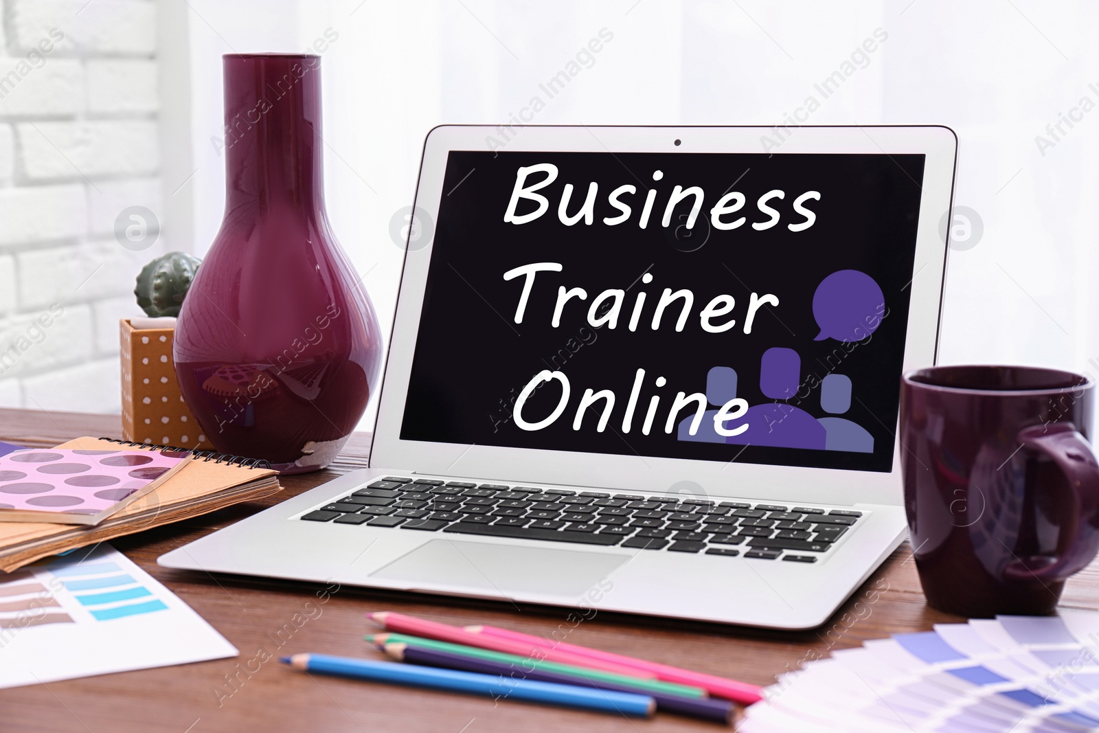 Image of Modern laptop with text BUSINESS TRAINER ONLINE on wooden table indoors