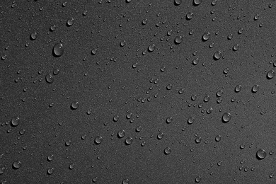 Water drops on black background, top view