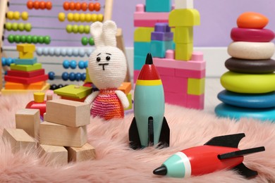 Photo of Set of different toys on faux fur rug