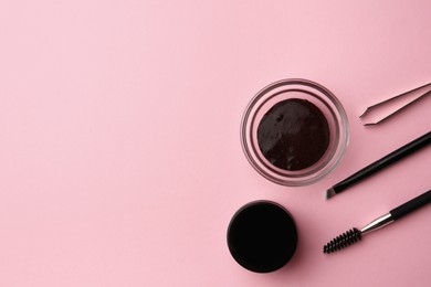 Photo of Flat lay composition with eyebrow henna and professional tools on pink background, space for text