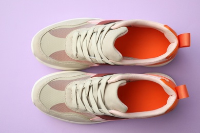 Photo of Pair of stylish shoes on lilac background, top view