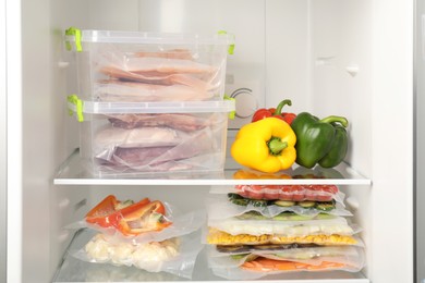 Photo of Vacuum bags with different products in fridge. Food storage