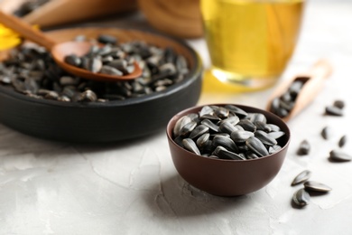 Photo of Bowl with sunflower seeds on table, closeup