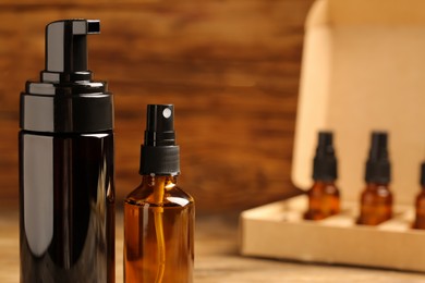 Photo of Bottles of oil on wooden table, closeup with space for text. Natural cosmetics