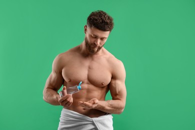 Photo of Handsome man with body lotion on green background