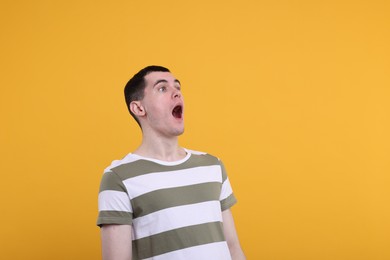 Photo of Portrait of surprised man on orange background, space for text