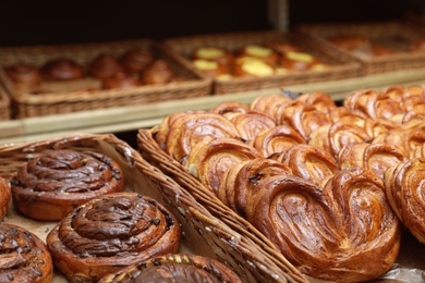 Photo of Wicker trays with different sweet buns in bakery