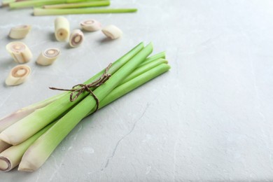 Photo of Whole and cut fresh lemongrass on light table. Space for text